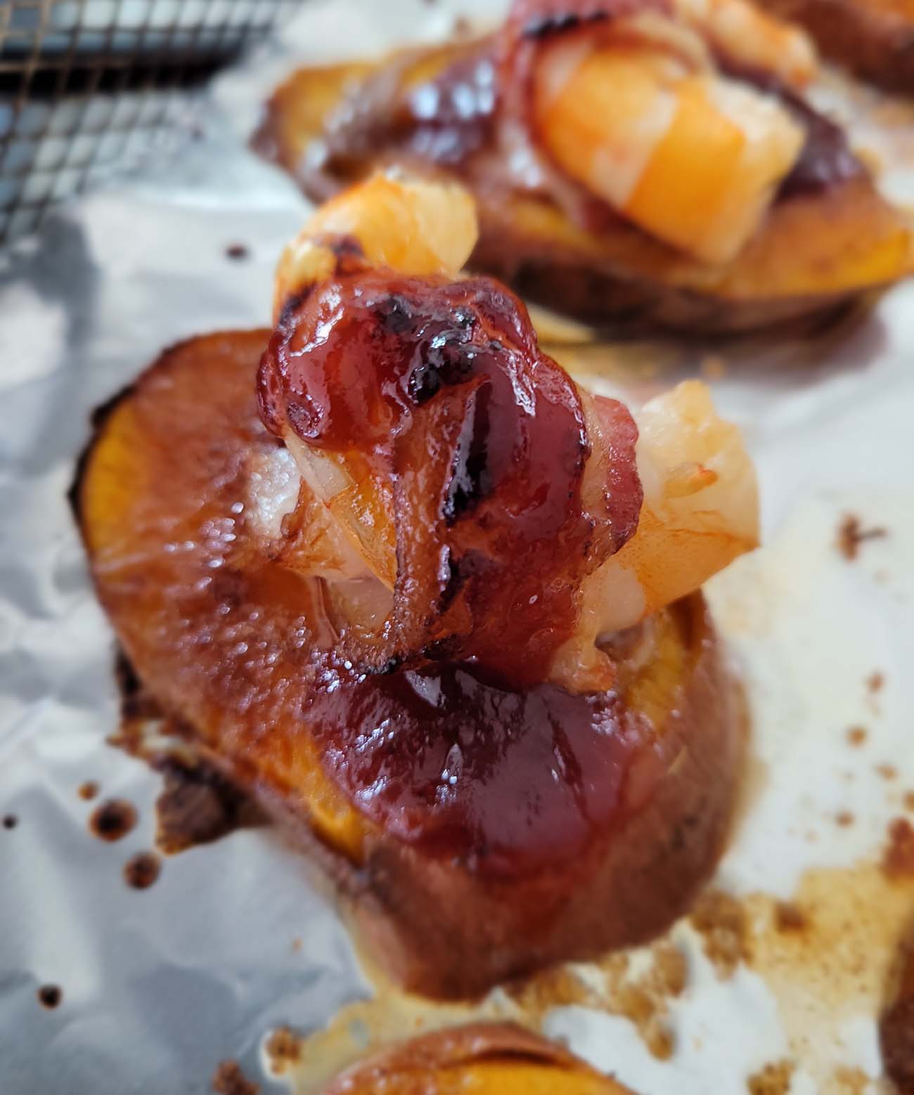 bacon wrapped shrimp on sweet potato round with BBQ sauce