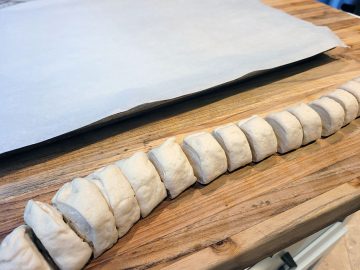 pizza dough rolled up in a tube and sliced in smaller rounds