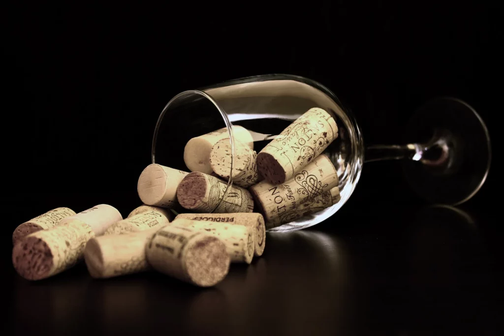 wine glass filled with corks laying on it's side