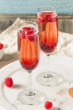 Kir Royale and champagne in 2 champagne flute with raspberries