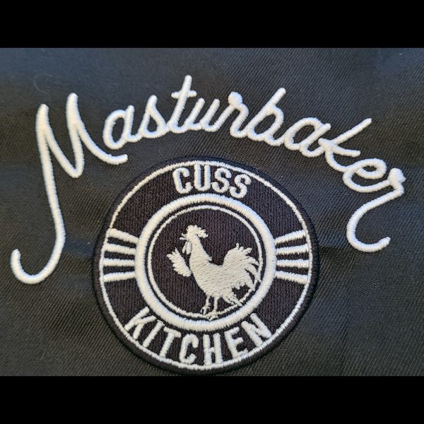 Embroidered Masturbaker Cuss Kitchen logo in white on black fabric