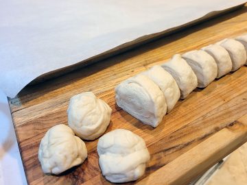 sliced pizza dough with a few rolled into rounds