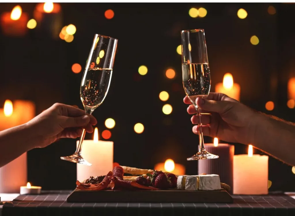 Champagne glasses being held in candlelight