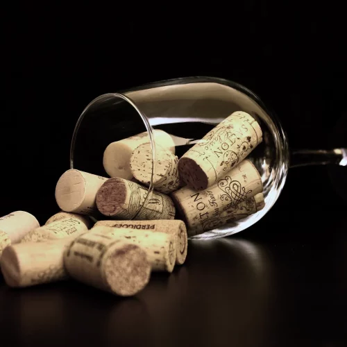 wine glass filled with corks laying on it's side