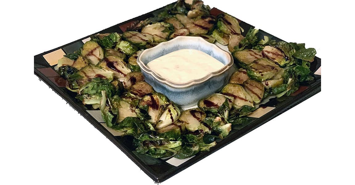 platter of roasted brussel sprouts with creamy dipping sauce