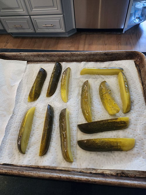 dill pickle spears on paper towel.