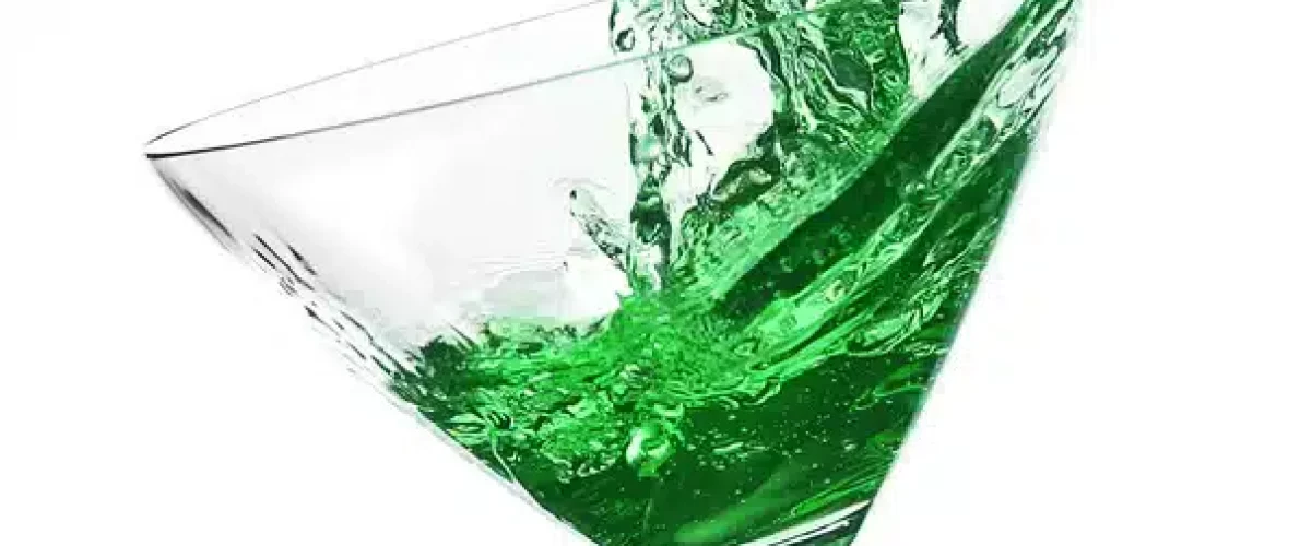 green martini splashing in a glass