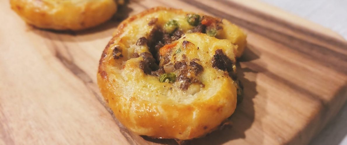 pastry rolled in a pinwheel filled with mashed potatoes, peas, carrots, and beef